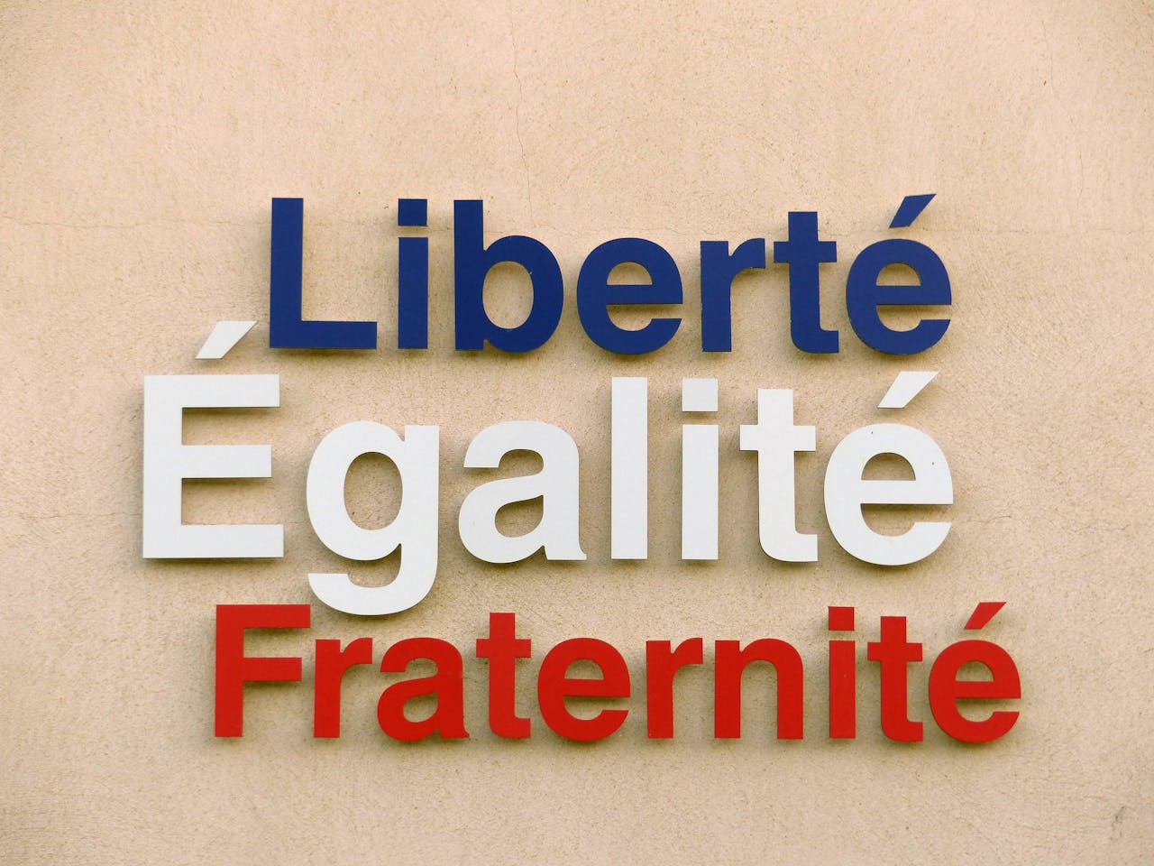 Bold text of Liberté, Égalité, Fraternité on a wall in France.